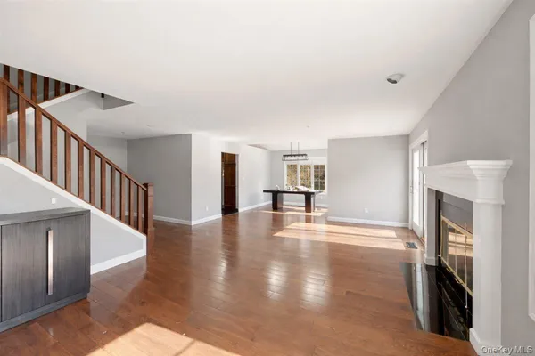 a view of a livingroom with wooden floor and kitchen space with a fireplace