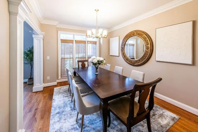 a view of a dining room and livingroom with furniture wooden floor a chandelier