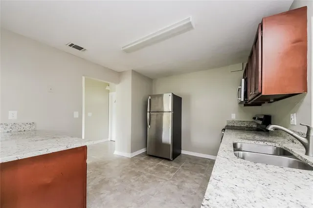 a kitchen with stainless steel appliances granite countertop wooden cabinets a stove a sink and dishwasher