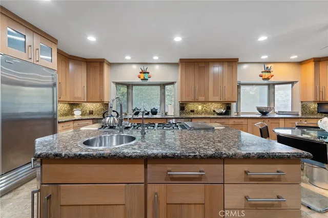 a kitchen with stainless steel appliances granite countertop a sink counter space cabinets and a large window