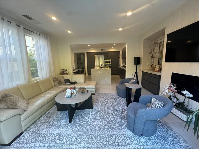 a living room with furniture a flat screen tv and a fireplace
