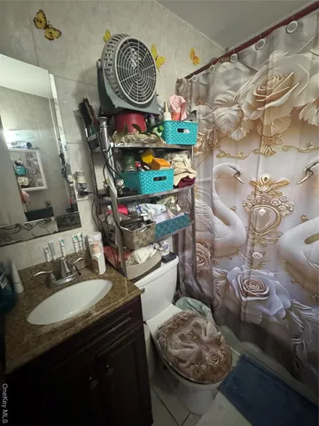 a bathroom with a sink mirror vanity and toilet