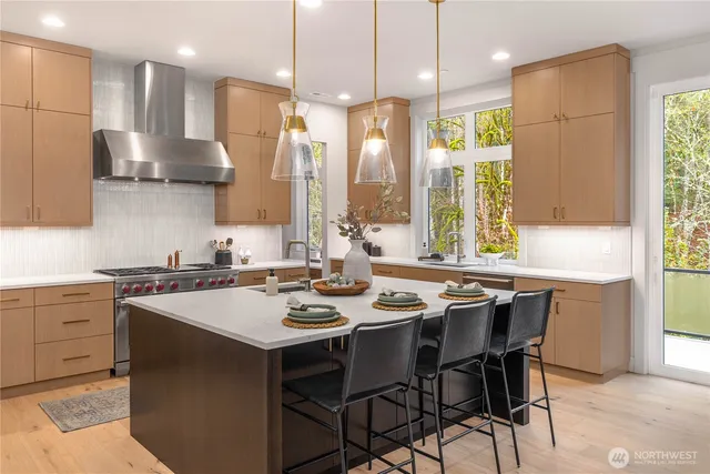 a kitchen that has a sink a stove counter space and stainless steel appliances