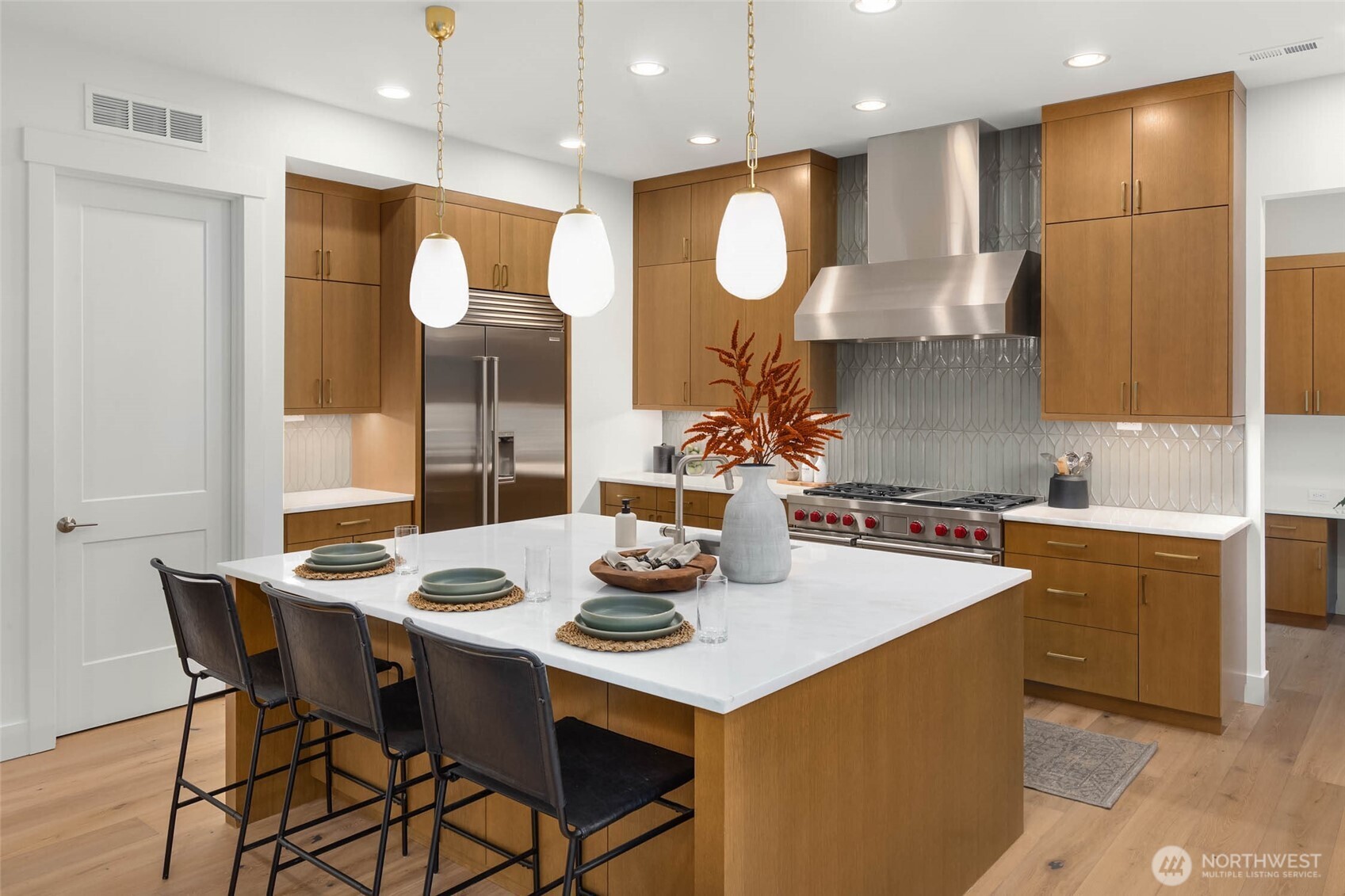 21021 Southeast 80th Street Issaquah, WA 98027 - Photo 18 of 38 a kitchen with stainless steel appliances kitchen island granite countertop a sink a stove a dining table and chairs