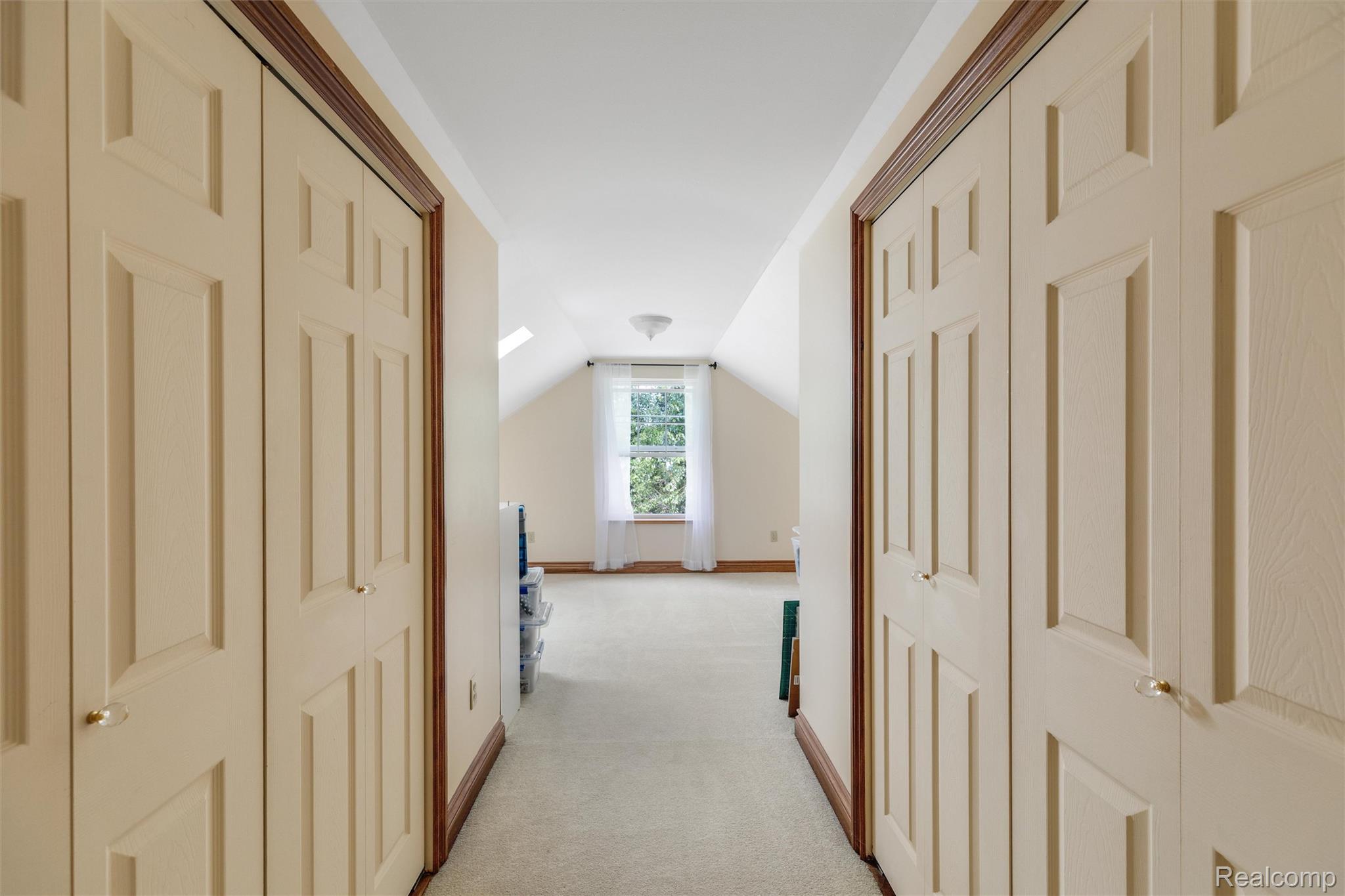 21280 Merriman Road New Boston, MI 48164 - Photo 44 of 65 Recessed lighting, sloped ceiling, window with white sheers, light carpet flooring, and two sets of bi-fold doors with paneling