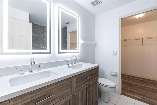 a bathroom with a sink toilet a mirror and vanity