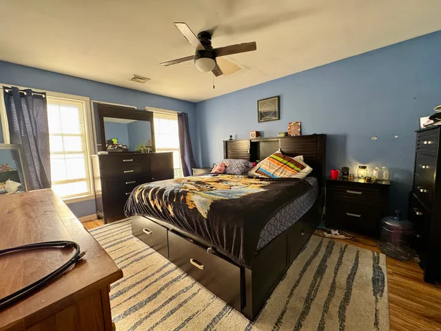 a bedroom with a bed and wooden floor