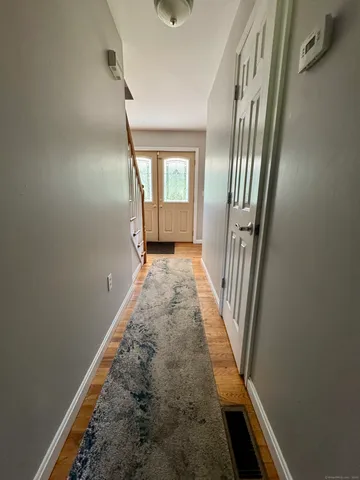 a view of a hallway with wooden floor and staircase