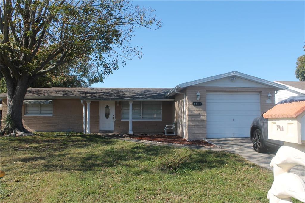 8911 Tropical Palm Way Port Richey, FL 34668 - Photo 1 of 1 a view of a house with yard and large tree
