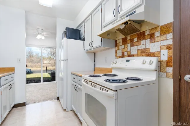 a kitchen that has a stove and a white refrigerator
