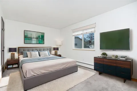 a bedroom with a bed and a flat screen tv