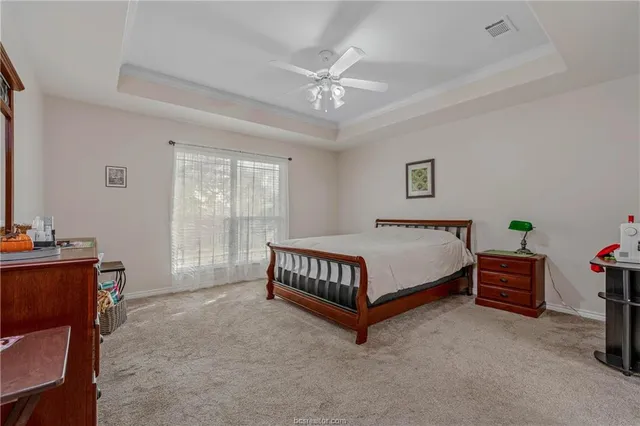 a spacious bedroom with a bed and a chandelier