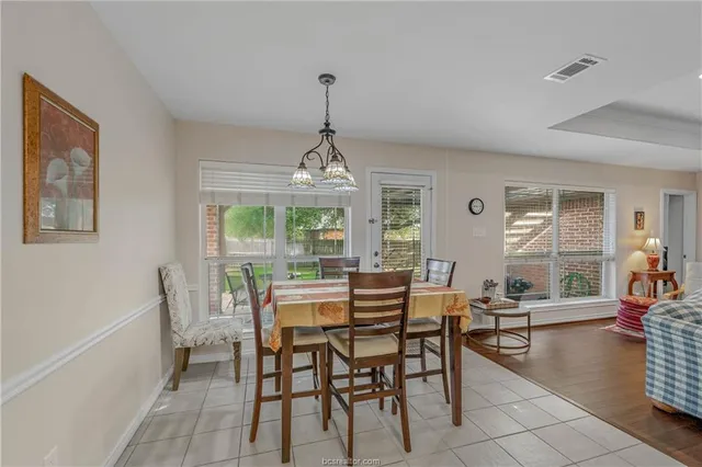 a dining room with furniture a chandelier and wooden floor