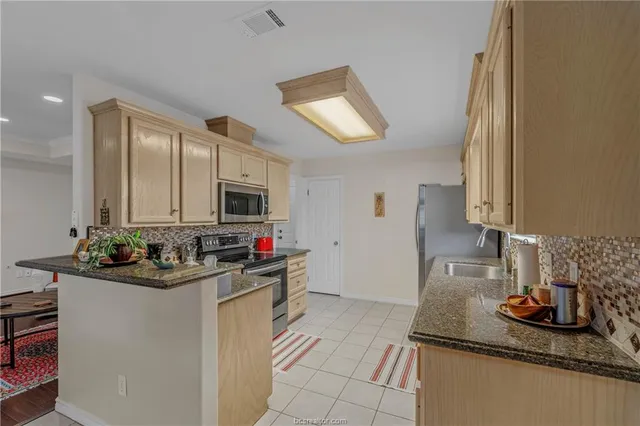 a kitchen with sink cabinets and stove top oven