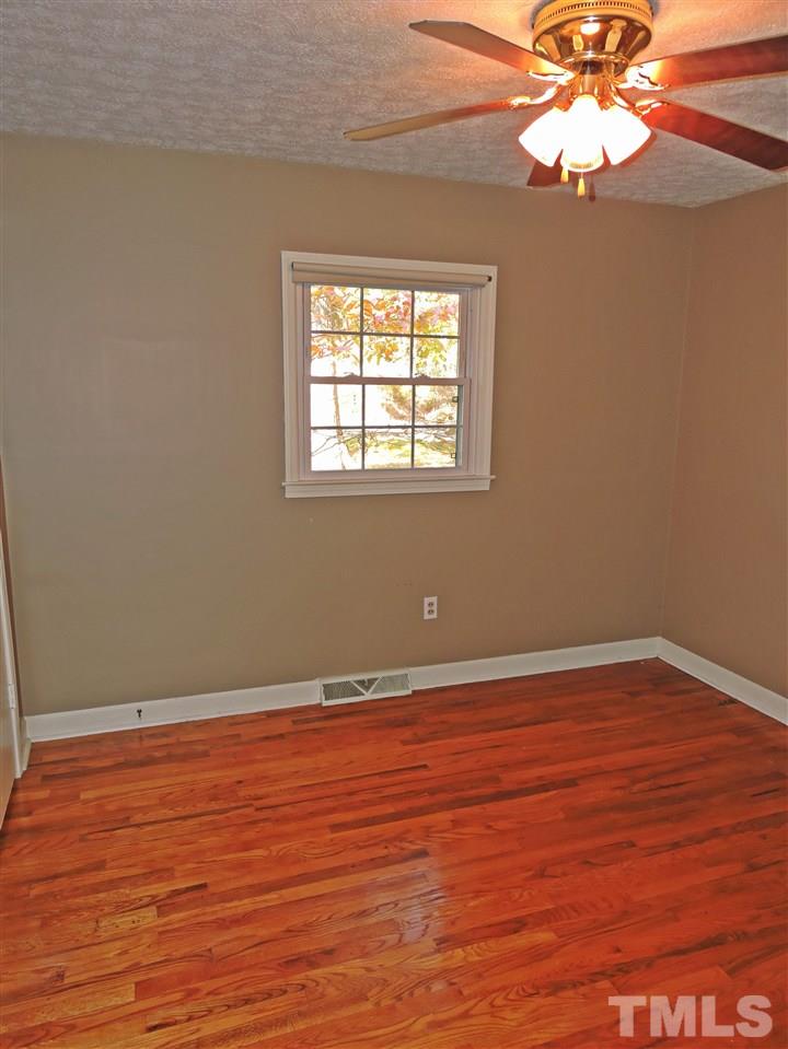 1228 Dover Street Roxboro, NC 27573 - Photo 4 of 11 an empty room with wooden floor and windows