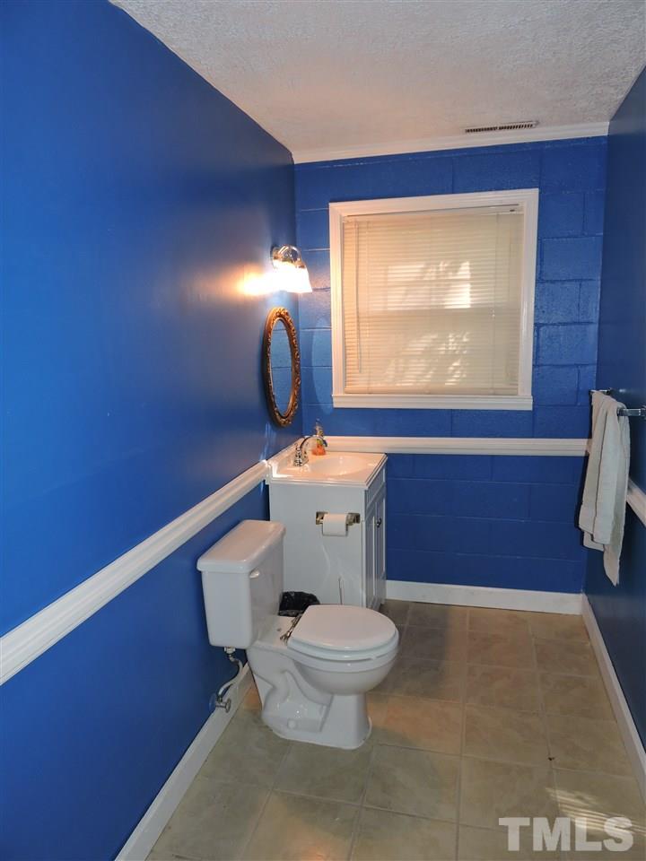 1228 Dover Street Roxboro, NC 27573 - Photo 9 of 11 a bathroom with a toilet a sink and mirror