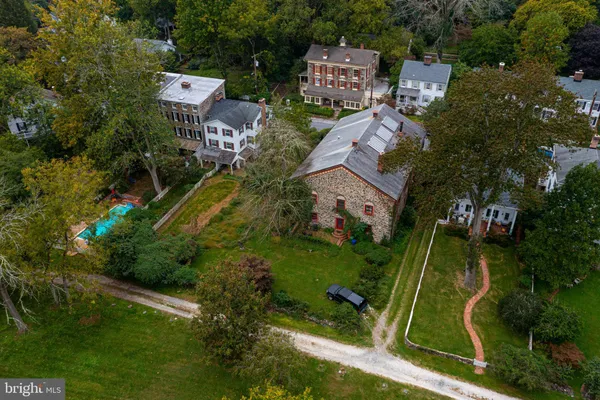 an aerial view of residential house with outdoor space and trees all around
