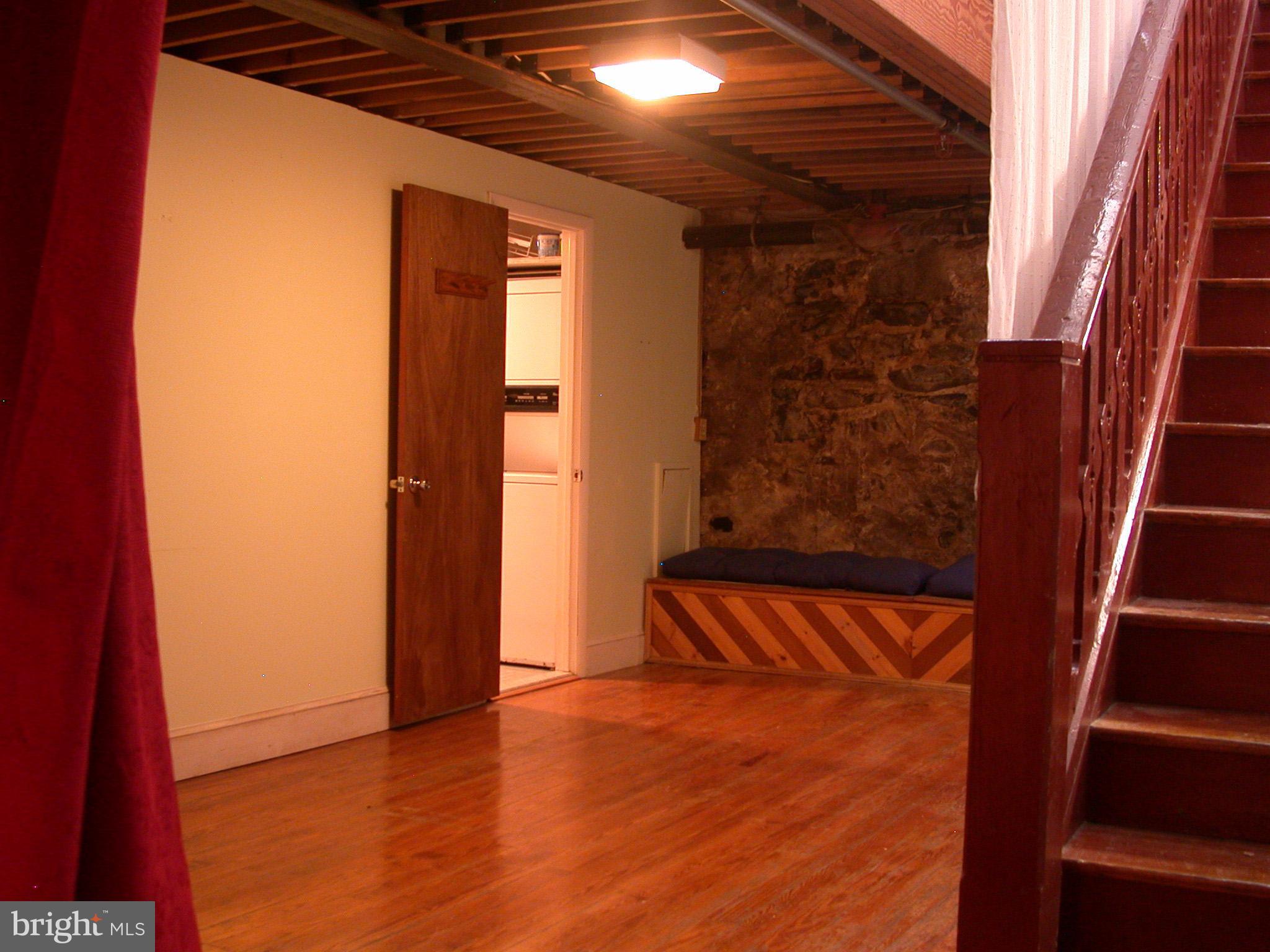 2423 Pickwick Road Baltimore, MD 21207 - Photo 29 of 34 a view of an empty room with wooden floor and stairs
