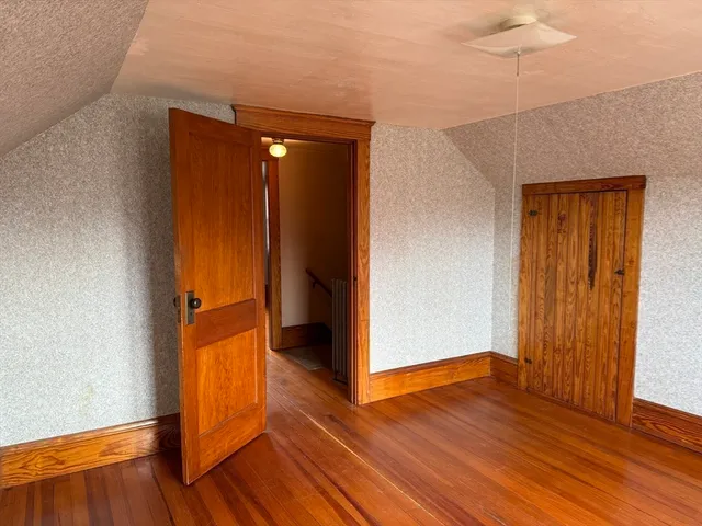 an empty room with wooden floor and closet