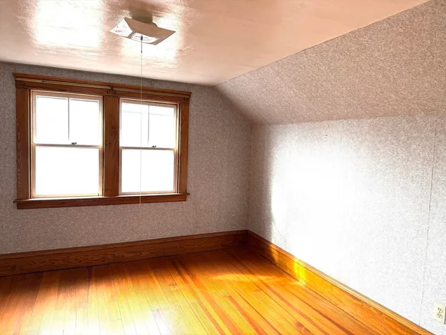 a view of a room with wooden floor and a window