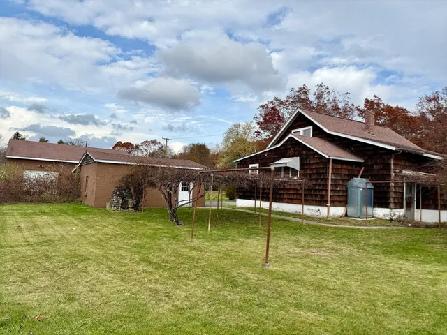 a view of a house with a yard and sitting area