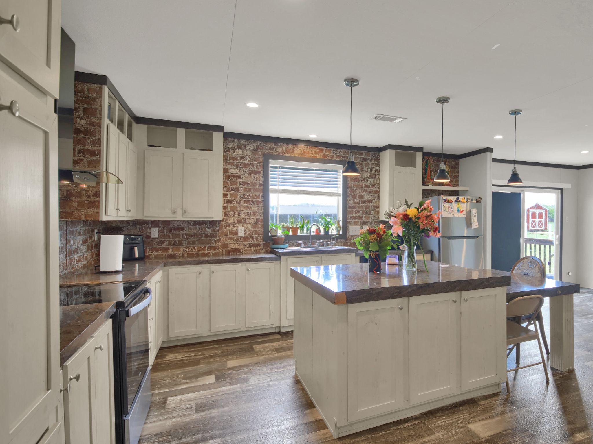 271 Alma Lane Kyle, TX 78640 - Photo 6 of 25 a kitchen with kitchen island granite countertop a sink stove and cabinets