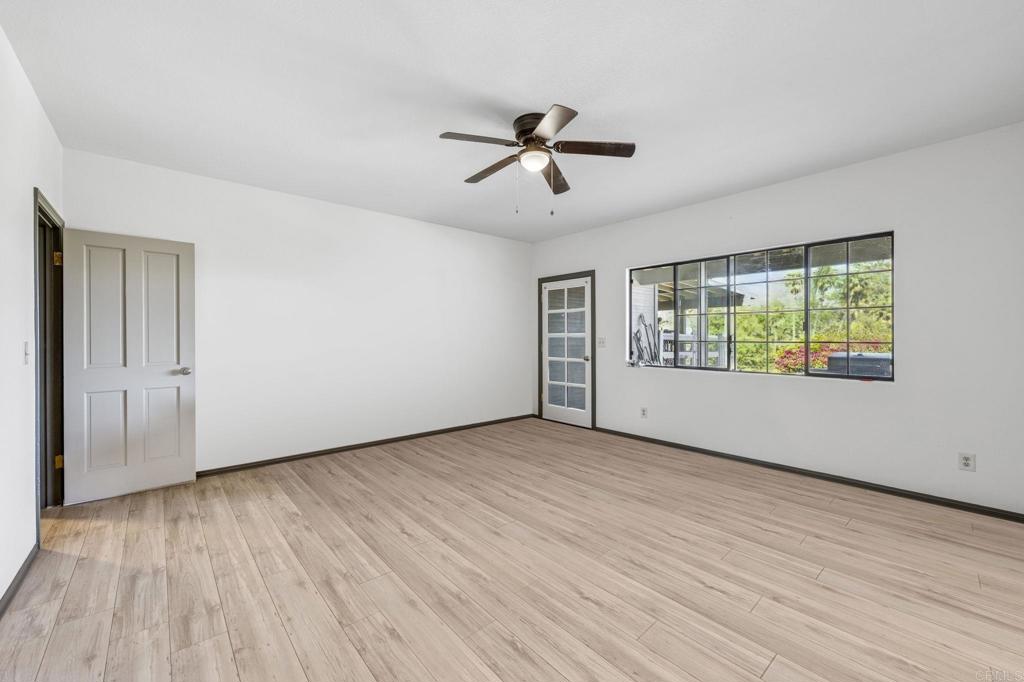 3223 Olive Hill Road Fallbrook, CA 92028 - Photo 28 of 64 an empty room with wooden floor a ceiling fan and windows