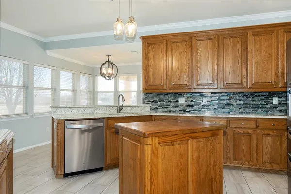a kitchen with granite countertop a sink and a wooden floors