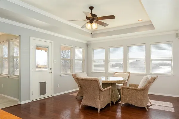 a living room with furniture large windows and wooden floor