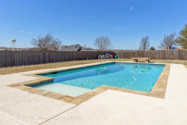 a swimming pool with outdoor seating and yard