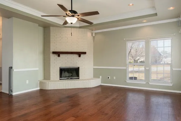 a view of empty room with wooden floor and fireplace