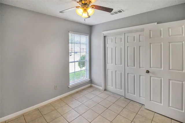 an empty room with chandelier fan