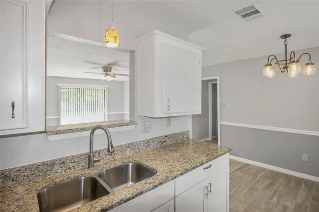 a kitchen with stainless steel appliances granite countertop a sink a granite counter tops and a wooden cabinets