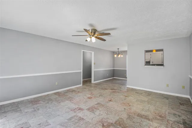 an empty room with fan and windows