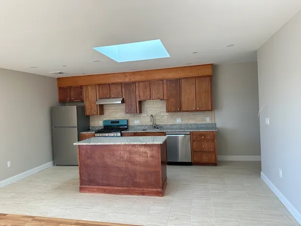 a kitchen with stainless steel appliances granite countertop a stove a sink and a refrigerator