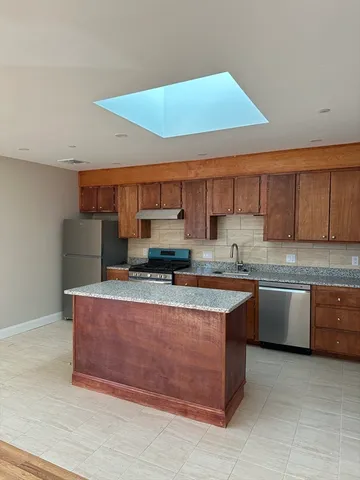 a kitchen with stainless steel appliances granite countertop a stove a sink and a refrigerator