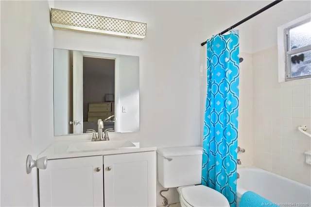 a bathroom with a sink a toilet and shower curtain