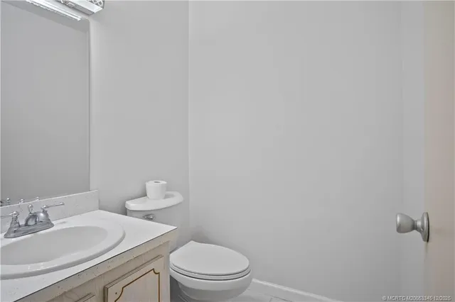 a bathroom with a granite countertop toilet and a sink