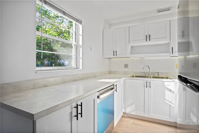 a kitchen with granite countertop white cabinets and white appliances