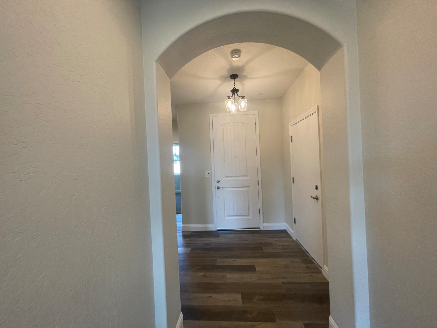 16171 West Monterey Avenue Kerman, CA 93630 - Photo 12 of 19 a view of a hallway with wooden floor and a bathroom