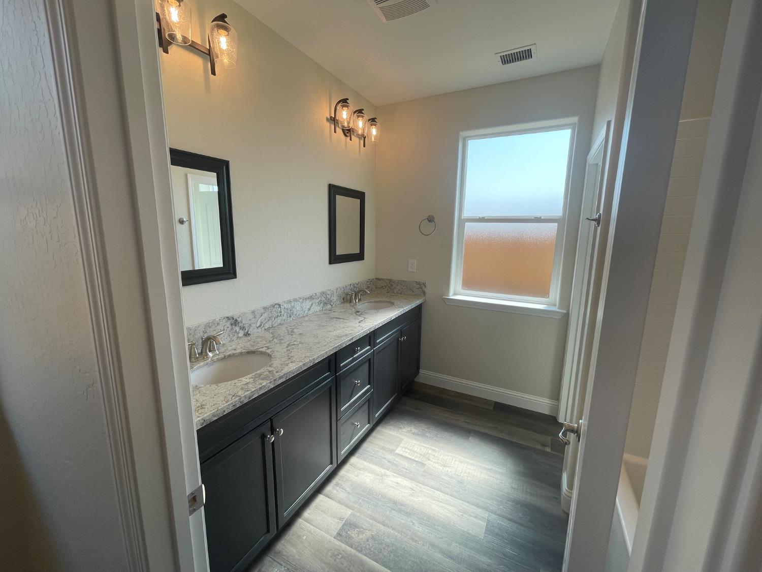 16171 West Monterey Avenue Kerman, CA 93630 - Photo 15 of 20 a bathroom with a granite countertop sink and a mirror