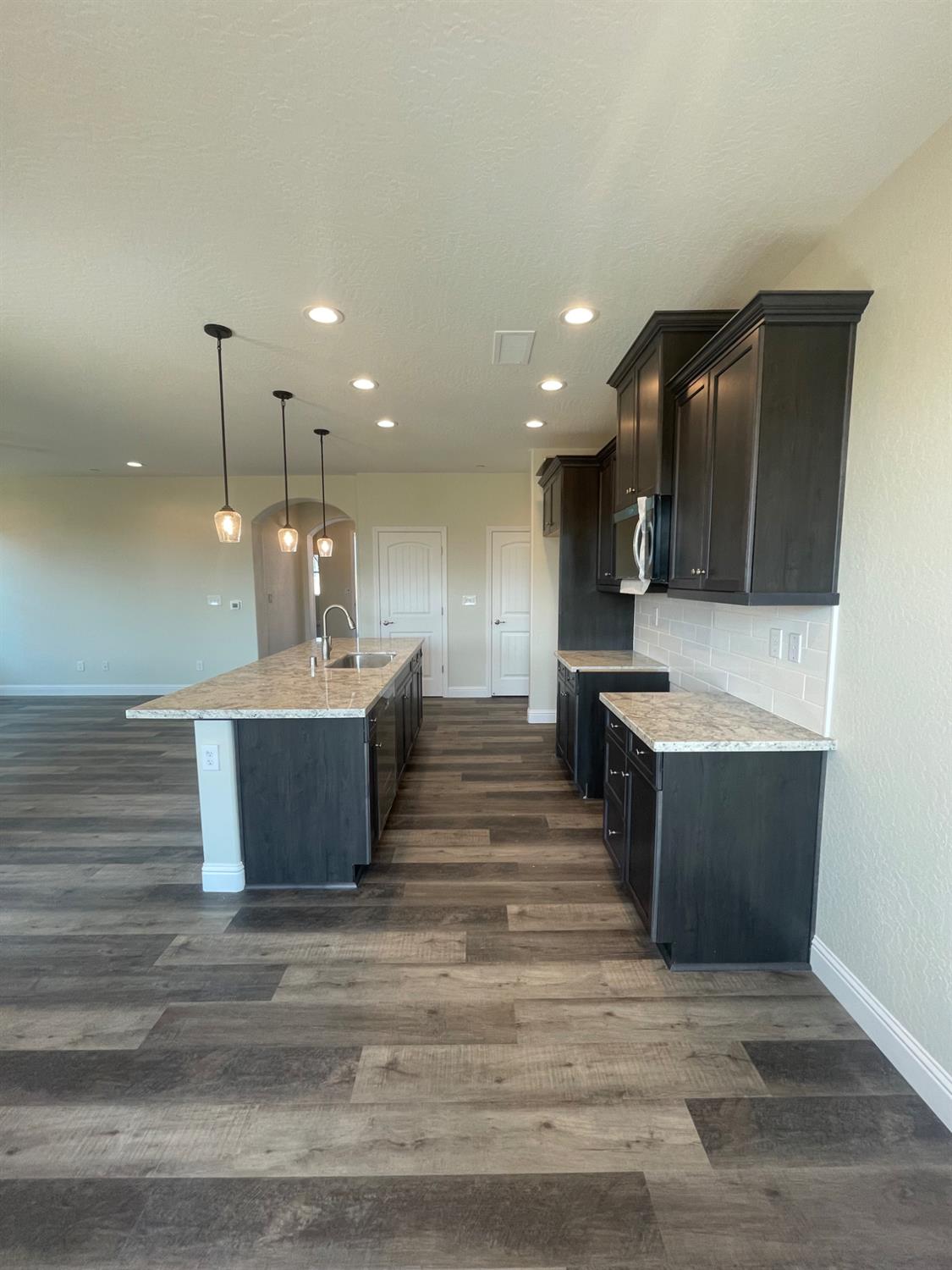 16171 West Monterey Avenue Kerman, CA 93630 - Photo 5 of 19 a large kitchen with kitchen island a sink stainless steel appliances and cabinets