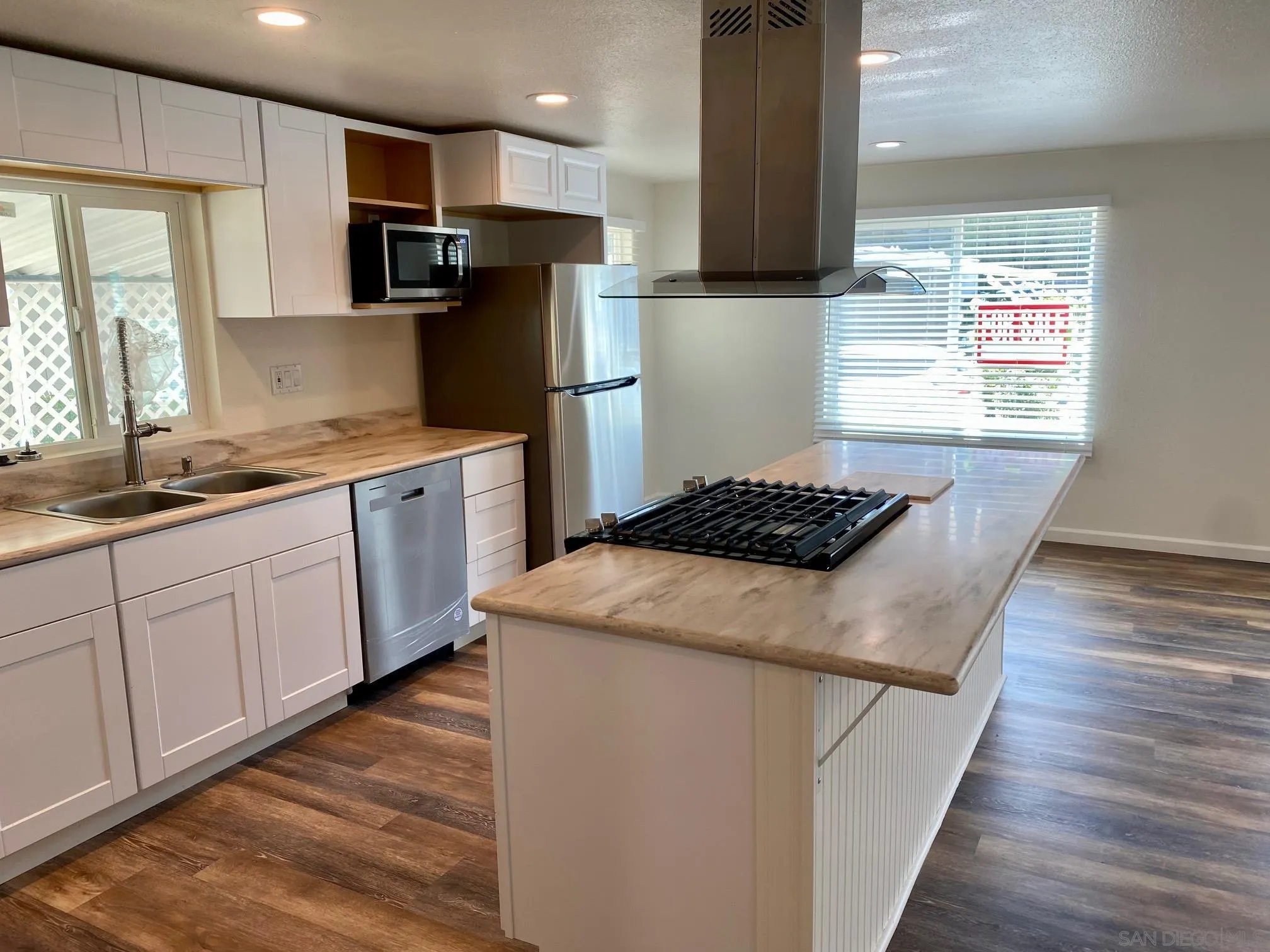 6480 Katherine Road, Unit 88 Simi Valley, CA 93063 - Photo 6 of 15 a kitchen with stainless steel appliances a refrigerator sink and wooden floor