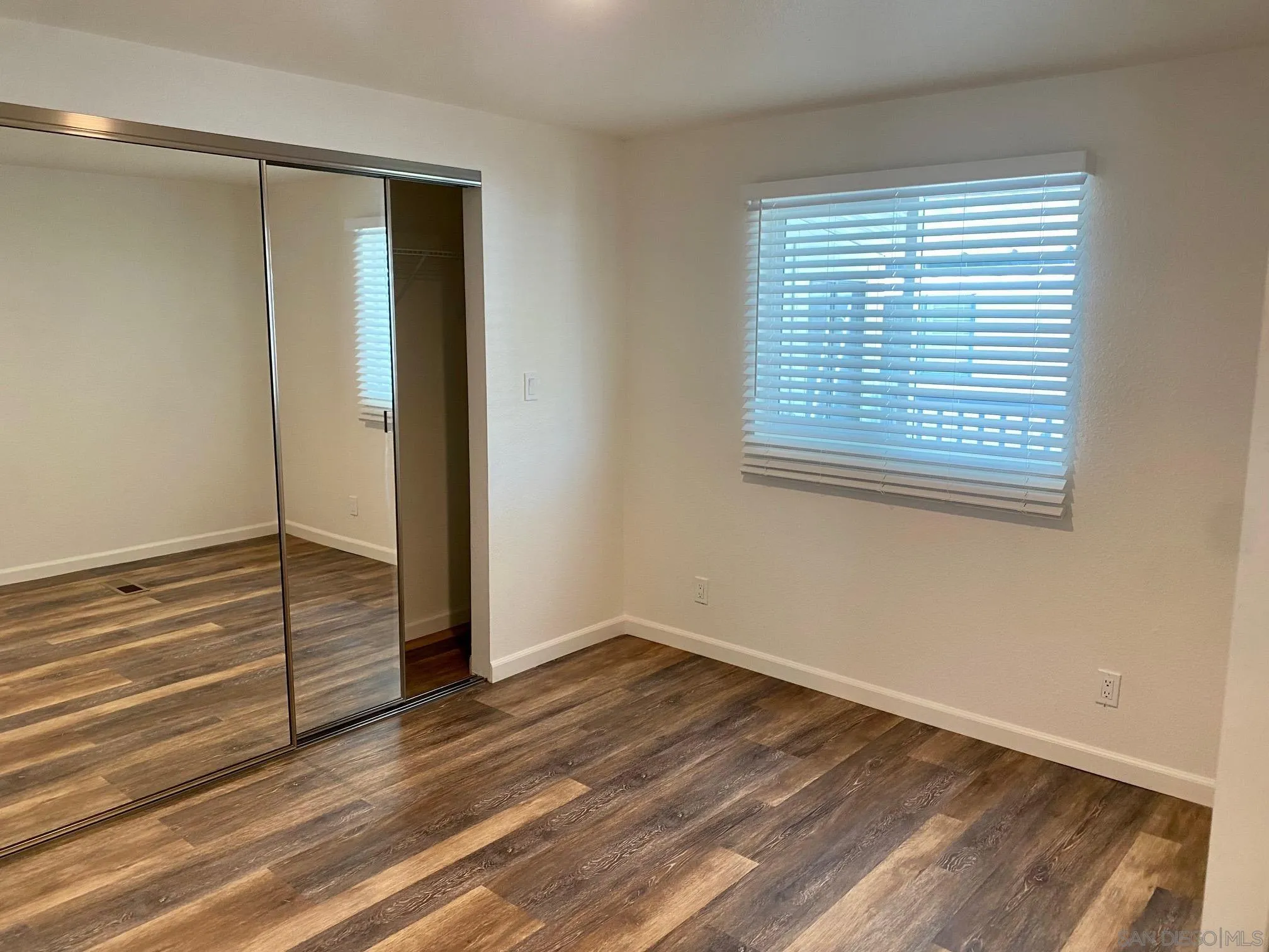 6480 Katherine Road, Unit 88 Simi Valley, CA 93063 - Photo 7 of 15 a view of an empty room with wooden floor and a window
