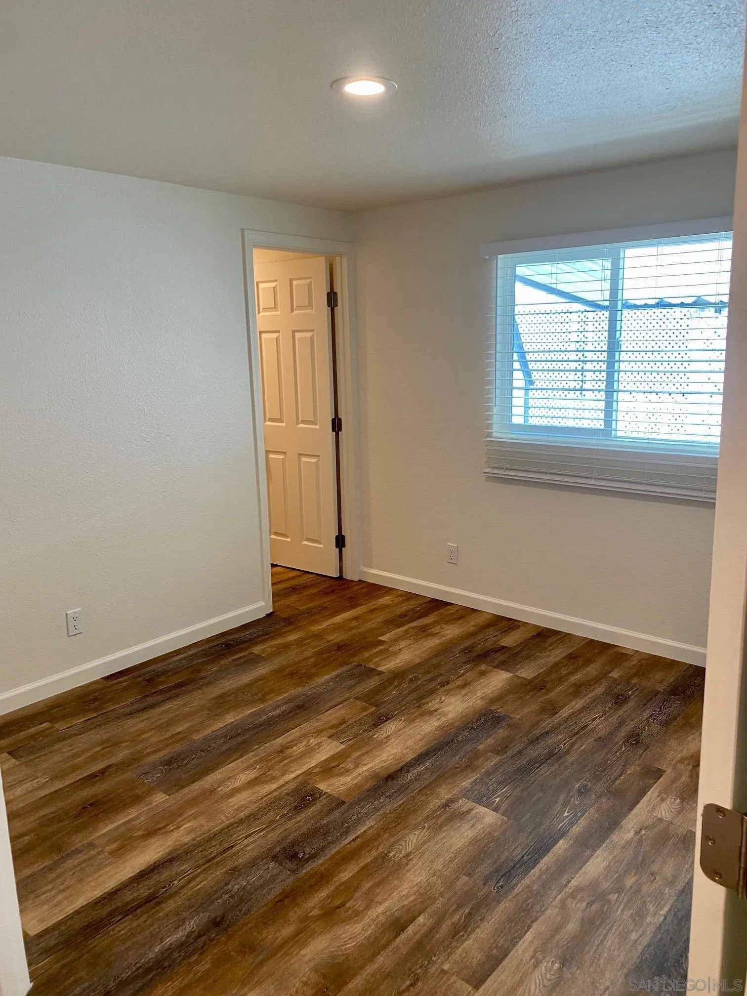 6480 Katherine Road, Unit 88 Simi Valley, CA 93063 - Photo 10 of 15 a view of an empty room with wooden floor and a window