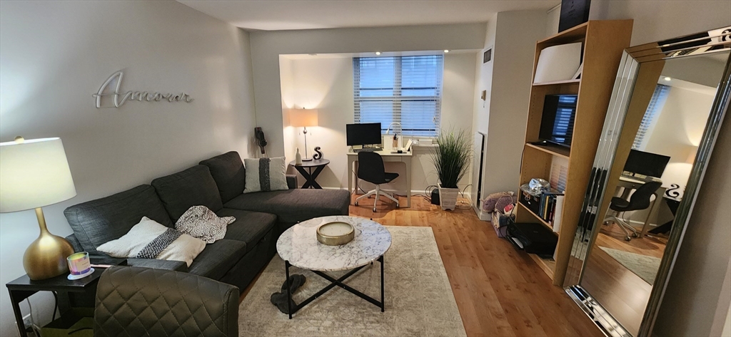 170 Tremont Street, Unit 606 Boston, MA 02111 - Photo 3 of 19 a living room with furniture and a flat screen tv