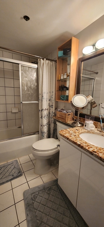 170 Tremont Street, Unit 606 Boston, MA 02111 - Photo 7 of 19 a bathroom with a granite countertop sink a toilet a mirror and shower