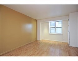 170 Tremont Street, Unit 606 Boston, MA 02111 - Photo 8 of 19 a view of an empty room with wooden floor and a window
