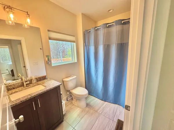 a bathroom with a granite countertop sink toilet and shower
