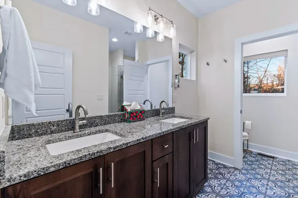 a bathroom with a granite countertop sink a large mirror and vanity